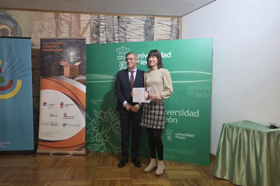 La Dra. Estela Fernández con el Presidente del Consejo Social de la Universidad de León. Estela sostiene el diploma del premio. Tras ellos hay un photocall con logos de la ULe, FGULEM, FUESCYL, tCUE y Junta de Castilla y León.